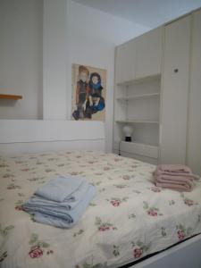 a bedroom with a bed with towels on it at Tigullio Vacations Il Ciliegio Apartment in Leivi