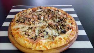 eine Pizza auf einem Tisch in der Unterkunft Villa Grand Bitola in Bitola