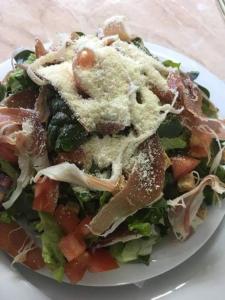 einen Salat auf einem weißen Teller auf einem Tisch in der Unterkunft Villa Grand Bitola in Bitola