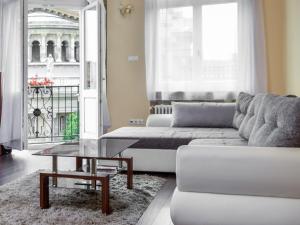 uma sala de estar com um sofá branco e uma mesa em Basilica Apartments em Budapeste
