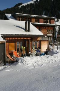 una cabaña en la nieve con gente sentada en una mesa en Bergdohle en Adelboden