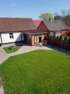 a house with a backyard with a lawn at Zvaigžņu māja in Pāvilosta
