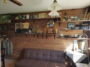 a living room with wooden walls and a leather couch at Zvaigžņu māja in Pāvilosta