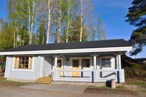 a small white house with a black roof at Hotel Hanhi Cottages in Lapinjärvi