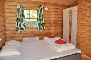 a bedroom with a bed in a log cabin at Hotel Hanhi Cottages in Lapinjärvi