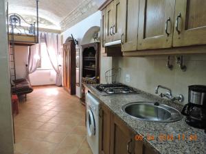 a kitchen with a sink and a stove at Casa Neto Studio in Fuzeta