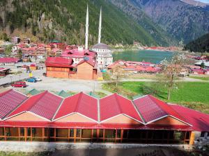 een groot gebouw met rode daken naast een meer bij Çakıroğlu Villa Kent in Uzungol