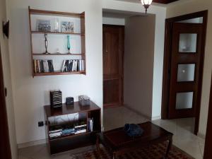 een woonkamer met een tafel en een boekenplank bij Océan in Rabat