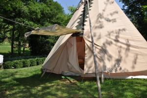 Augirein的住宿－Camping jardin La Vie en Vert en Ariège，坐在院子里草上的帐篷