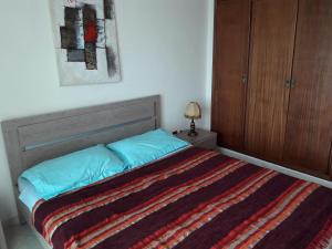 een slaapkamer met een bed en een houten kast bij Océan in Rabat
