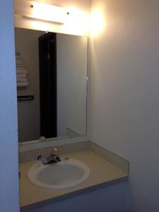 a bathroom with a sink and a large mirror at Americas Best Value Inn Laramie in Laramie