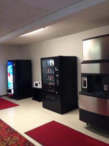 a room with two black refrigerators and a flat screen tv at Americas Best Value Inn Laramie in Laramie