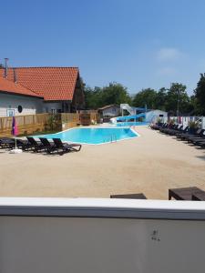 a large swimming pool with lounge chairs at Mobil Home Soulac in Soulac-sur-Mer