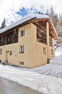 a building with a gambrel roof in the snow at Chesa Gulas - La Punt-Chamues-ch in La Punt-Chamues-ch