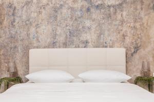 una camera da letto con un letto bianco con due cuscini di Jaspers Boutique Rooms a Berlino