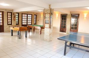 a room with two tables and a ping pong table at Fazenda Hotel Pedra dos Ventos in Quixadá