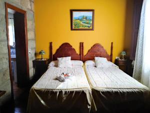 ein Schlafzimmer mit 2 Betten und einer gelben Wand in der Unterkunft Casa Rural Bella Vista in Granadilla de Abona