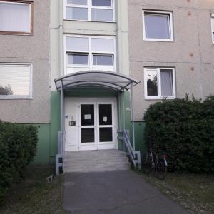 a building with a white door and a gate at Stúdió 18 Apartman in Kazincbarcika