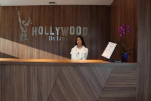 a woman is standing behind a reception desk at Hollywood De Luxe in Krasnodar