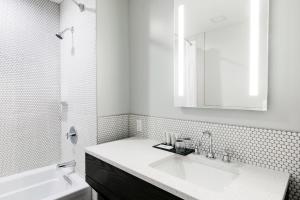 a white bathroom with a sink and a mirror at Mount Royal Hotel in Banff +17 photos