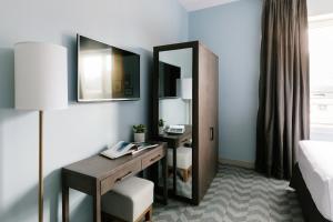 a hotel room with a desk and a mirror at Mount Royal Hotel in Banff