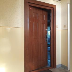una puerta de madera en la esquina de una habitación en Stúdió 18 Apartman, en Kazincbarcika
