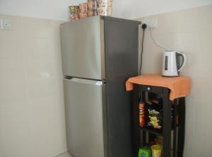 a stainless steel refrigerator in a kitchen with a shelf at Apartel opp Spice Arena in Bayan Lepas
