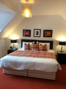 a bedroom with a large bed with two lamps at The Golden Larches in Lochearnhead