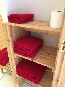 uma prateleira de madeira com toalhas vermelhas na casa de banho em The Golden Larches em Lochearnhead