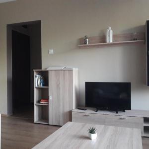 a living room with a flat screen tv on a table at Stúdió 18 Apartman in Kazincbarcika