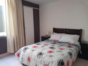 Un dormitorio con una cama con rosas rojas. en Hospedaje de Lidia, en Lima