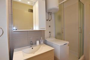 ein Badezimmer mit einem Waschbecken, einem WC und einem Spiegel in der Unterkunft Marine in Sukošan