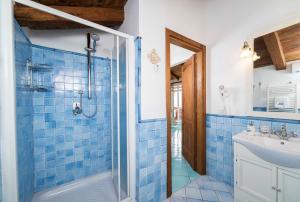 W wyłożonej niebieskimi kafelkami łazience znajduje się prysznic i umywalka. w obiekcie B&B Gattacicova w mieście Cava deʼ Tirreni