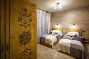 Un pat sau paturi într-o cameră la Tatrzański Ogród Regional Houses Zakopane