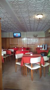 un ristorante con tavoli e sedie rossi e una TV di Piuké a San Carlos de Bariloche