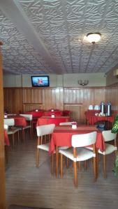 un restaurante con mesas y sillas rojas y TV en Piuké en San Carlos de Bariloche