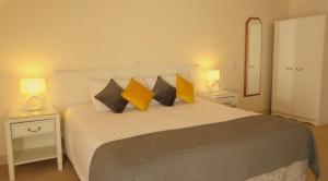 a bedroom with a bed with yellow pillows on it at The Lough and Quay in Warrenpoint