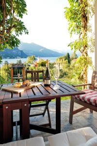 a wooden table with a bottle of wine and a glass at Villa Poletti in Bellagio