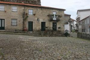 una antigua casa de piedra en una calle adoquinada en Casa do Largo do Cais, en Vila Nova de Cerveira