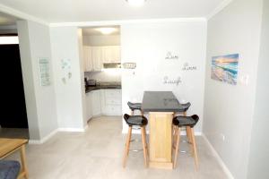 a small kitchen with a table and two stools at Beach One Bedroom Suite A22 in Ocho Rios