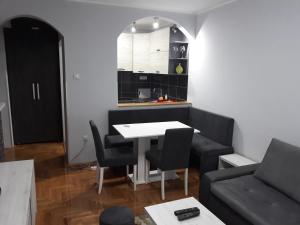 a living room with a table and a couch at Apartment Azzuro 2 in Novi Sad