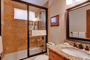 bagno con vasca, lavandino e doccia di Snow Flower Condos a Steamboat Springs