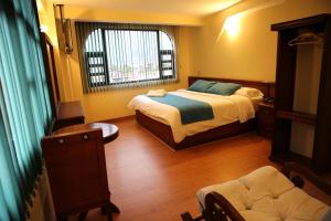 Habitación pequeña con cama y ventana en Hotel Donde Marcelo, en Baños