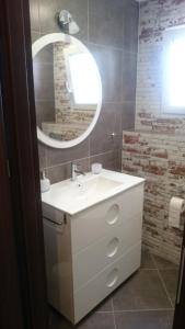 łazienka z białą umywalką i lustrem w obiekcie Apartment Joanna Grau de Gandia w mieście Los Mártires