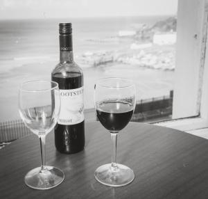 dos copas de vino en una mesa con una botella de vino en Royal Lion Hotel, en Tenby
