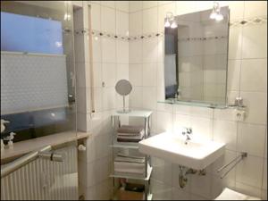 Baño blanco con lavabo y espejo en Ferienwohnung Bieniussa, en Gemünden