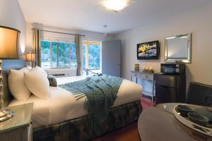Upper LakeにあるThe Lodge at Blue Lakesのベッドとテレビが備わるホテルルームです。