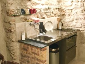 a kitchen with a sink and a brick wall at Cluny La Sorbonne Paris in Paris