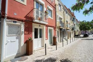 a cobblestone street with white doors and buildings at Apartamento Troino in Setúbal