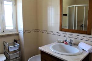 ein Badezimmer mit Waschbecken, Spiegel und Toilette in der Unterkunft Casa da Maria Moca in Fátima + 50 Fotos